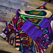 Colorful abstract apron with purple straps and pockets on a wooden table, from Black-owned brand soulPhoodie.