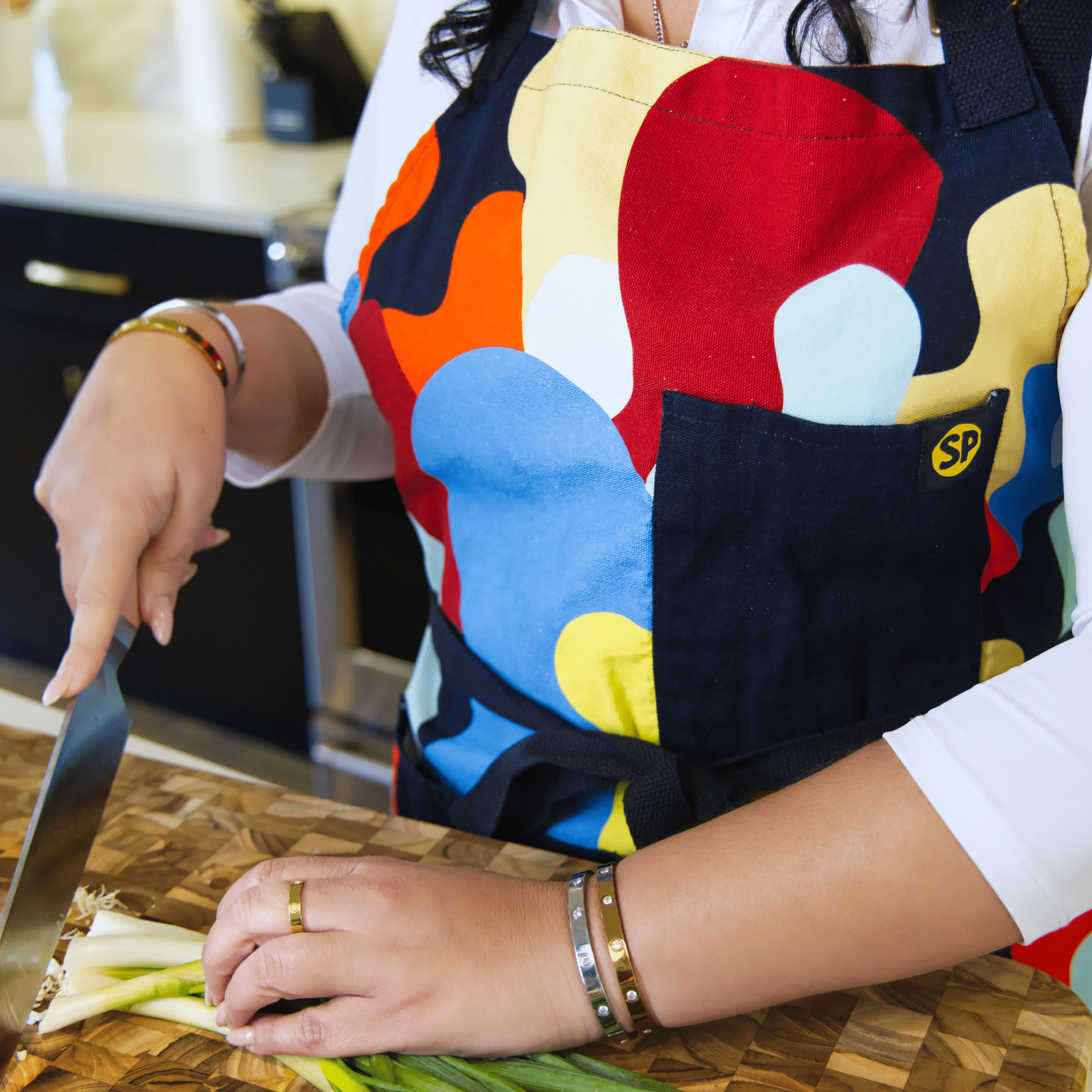 Chef cutting vegetables while wearing colorful Beryl Apron from Black-owned brand soulPhoodie